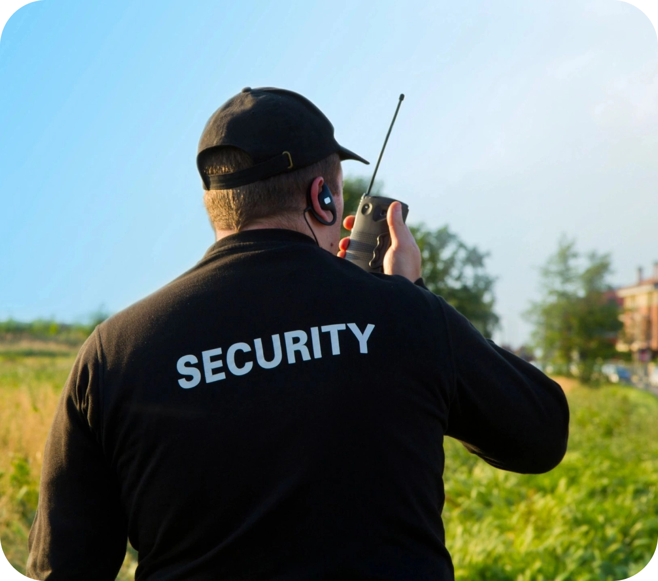 A man in black shirt holding a walkie talkie.