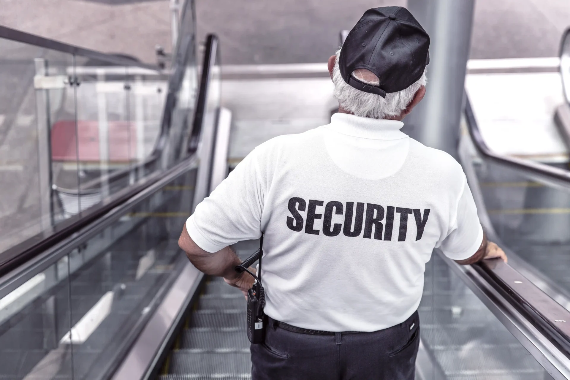 A security guard is standing on the escalator.